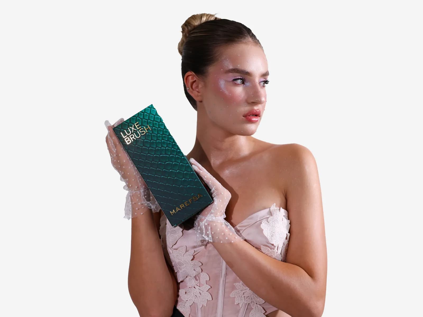 Model in sheer gloves holding the emerald LUXE BRUSH gift box